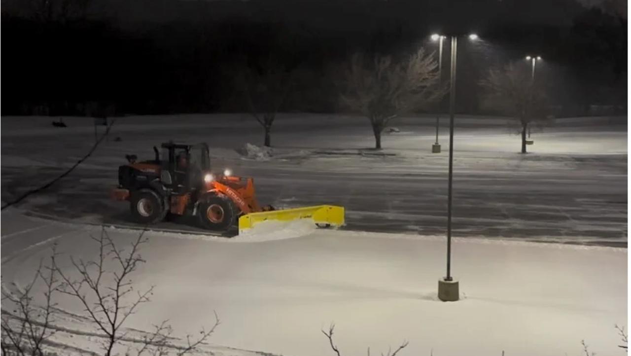 Rivers Edge loader clearing commercial parking lot at night