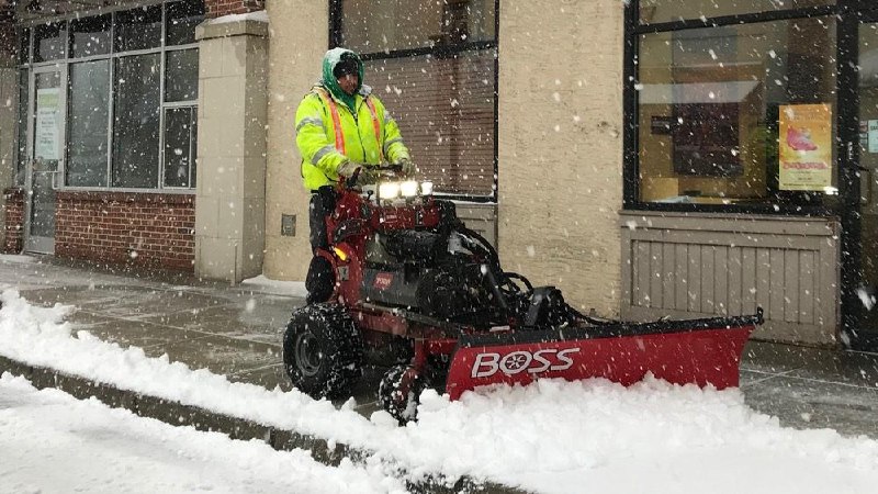 Rivers Edge crew clearing sidewalks during active snowfall